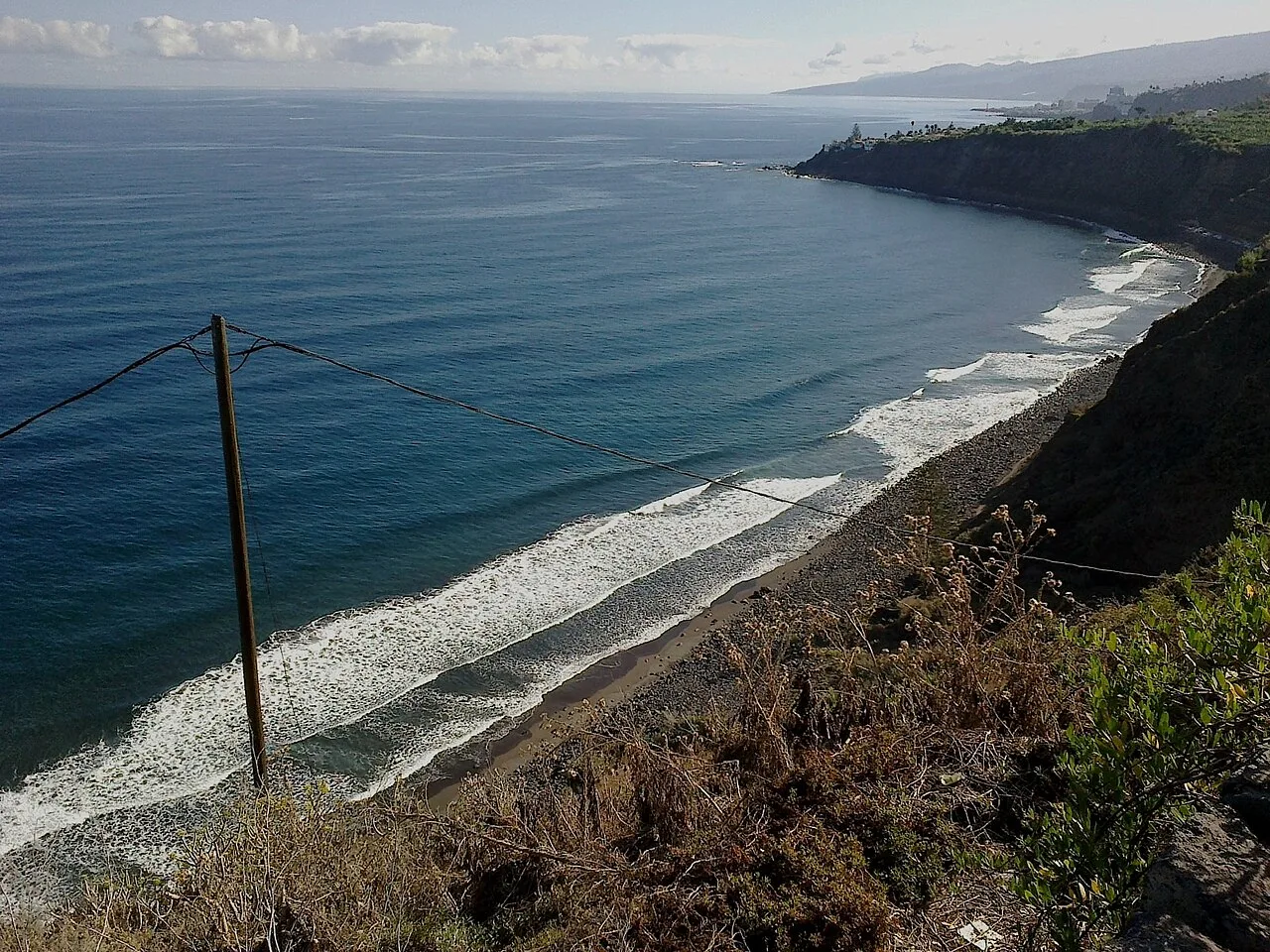 Playa del Socorro in Noord-Tenerife met zwart zand en groene heuvels op de achtergrond
